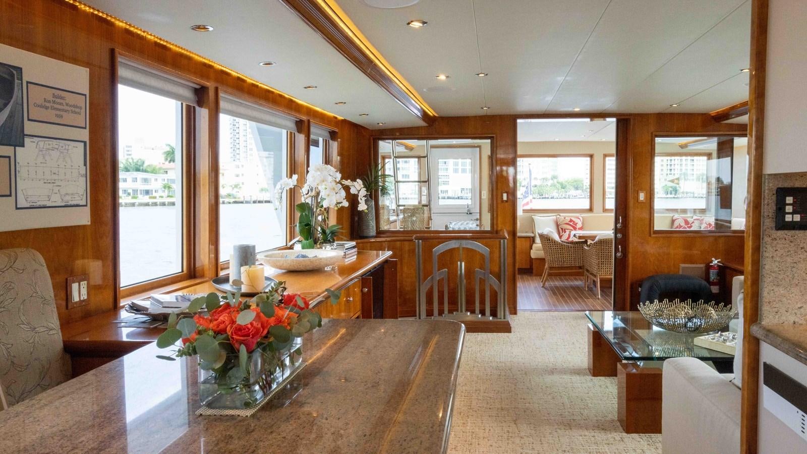 a large living room with a table and chairs aboard WELL DONE Yacht for Sale