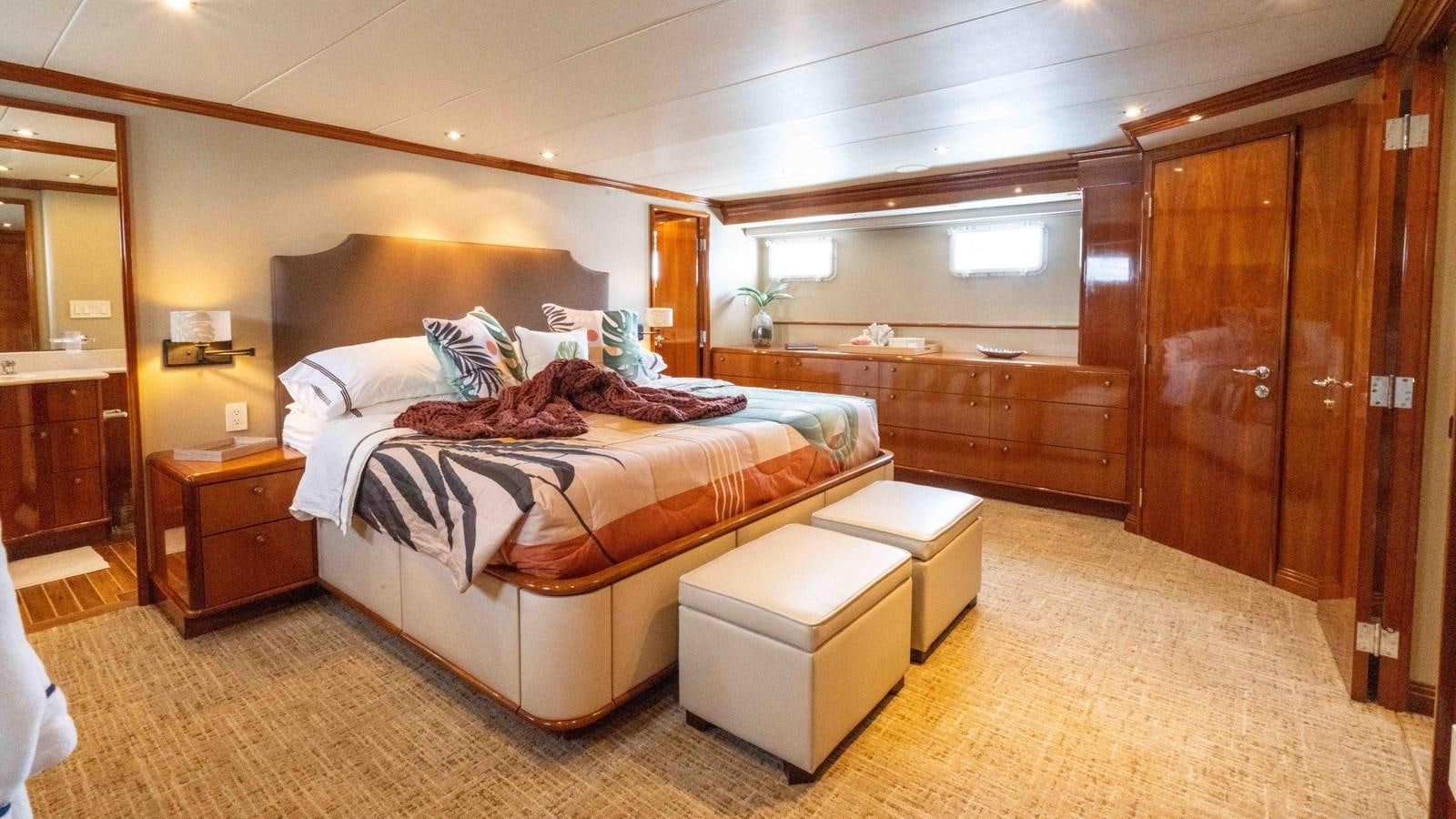a bedroom with a bed and a desk aboard WELL DONE Yacht for Sale