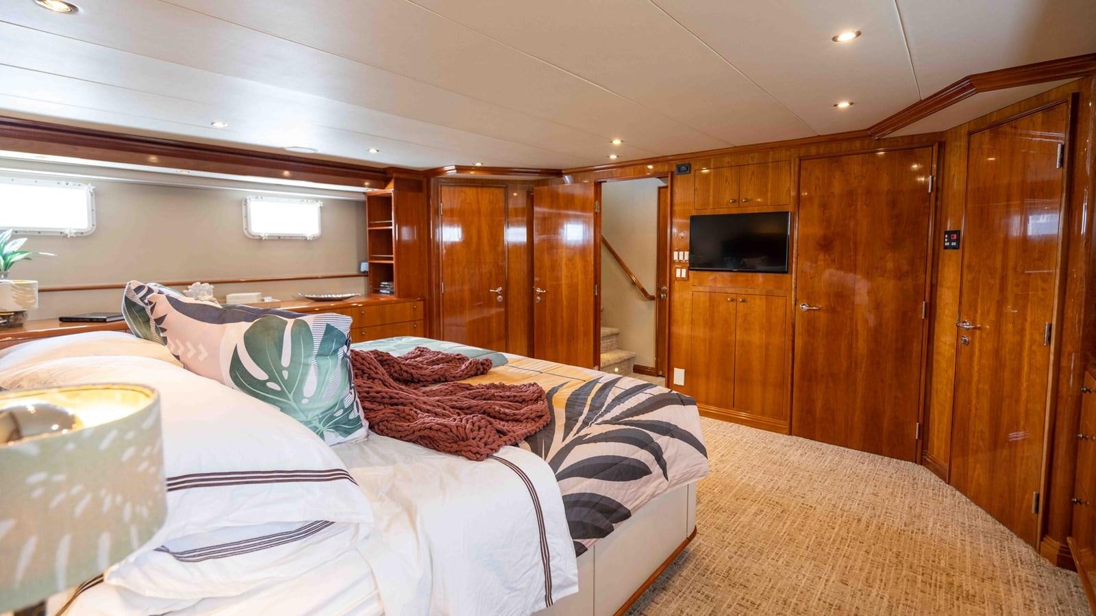 a bedroom with a bed and a television aboard WELL DONE Yacht for Sale
