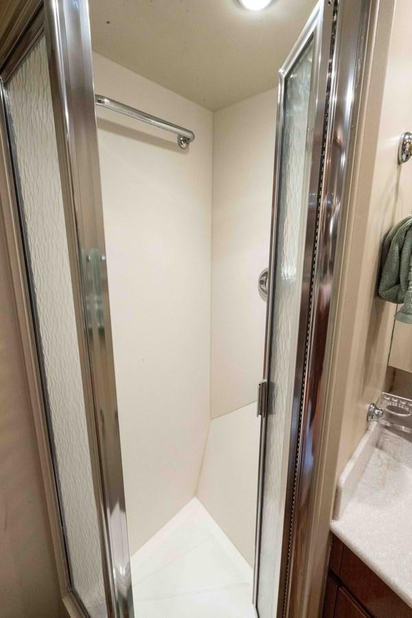 a bathroom with a glass shower door aboard WELL DONE Yacht for Sale