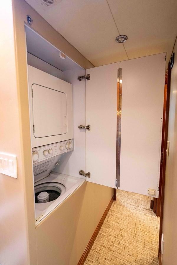 a white kitchen with a large white cabinet aboard WELL DONE Yacht for Sale