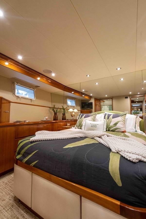 a bed with a blue and yellow blanket aboard WELL DONE Yacht for Sale