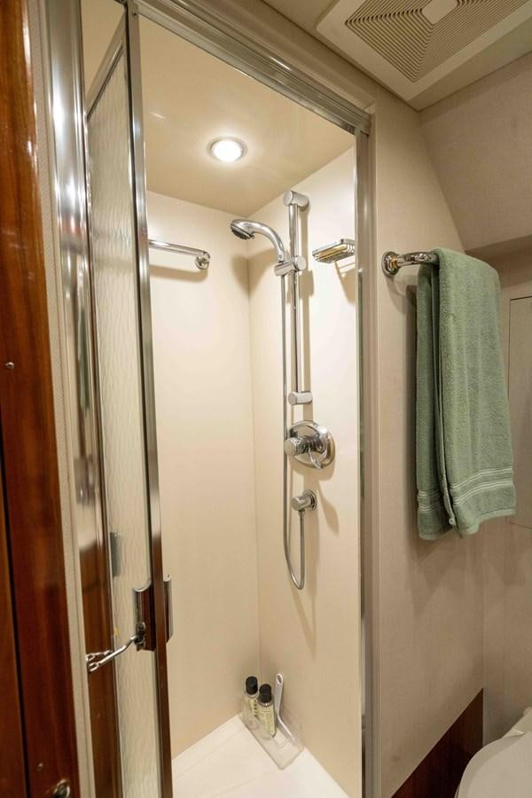a bathroom with a shower and a towel from the ceiling aboard WELL DONE Yacht for Sale