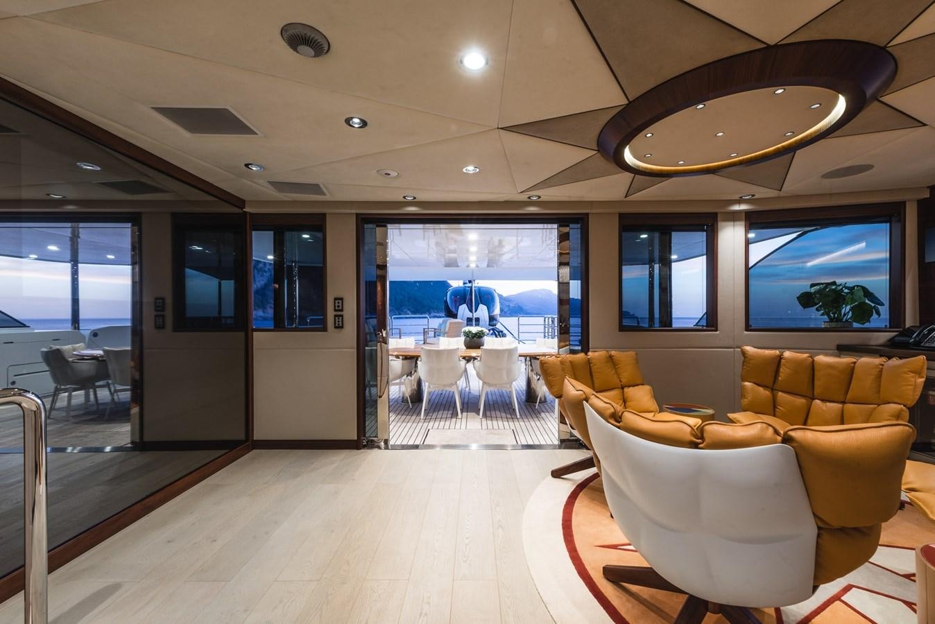 a room with a table chairs and a large window aboard FLYING MANTA Yacht for Sale