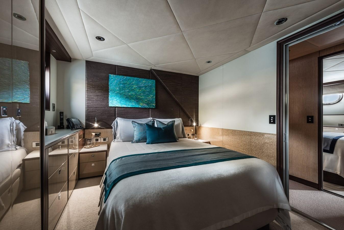 a bedroom with a bed and a television on the wall aboard FLYING MANTA Yacht for Sale