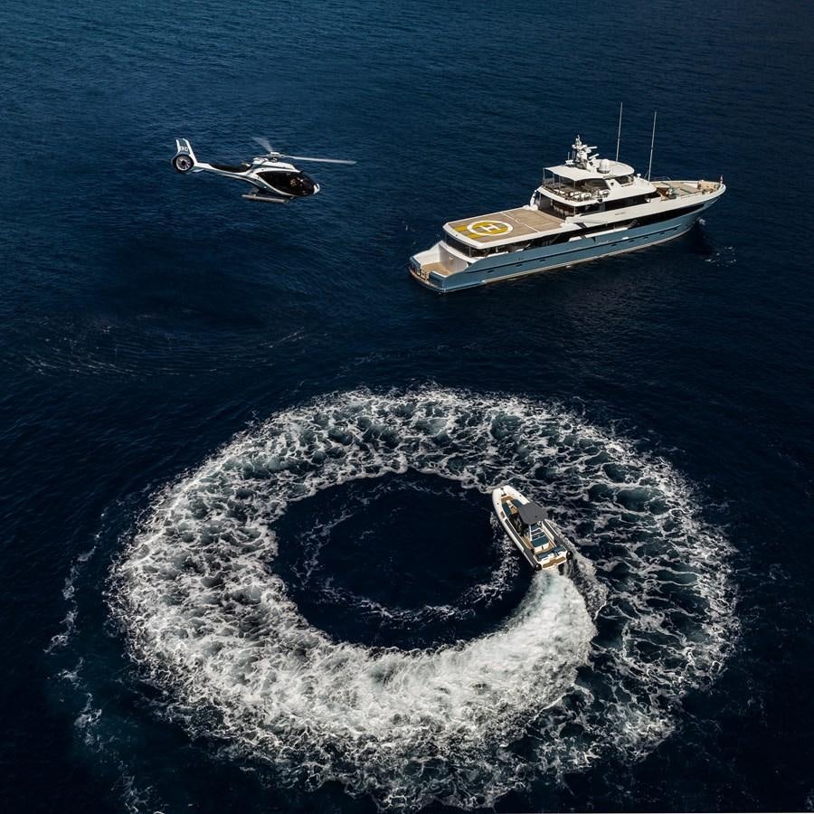 a plane flying over a ship in the ocean aboard FLYING MANTA Yacht for Sale