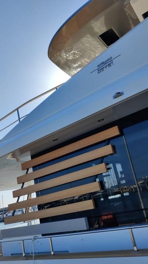 a building with a reflection of a car in the window aboard KIKI Yacht for Sale