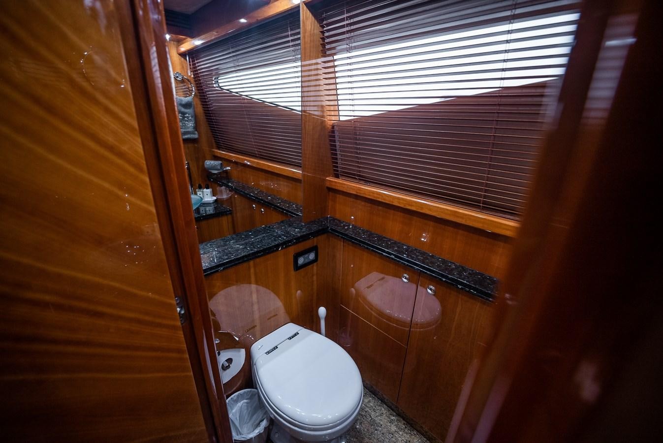 a bathroom with a toilet and a window aboard 105 MOTOR Yacht for Sale