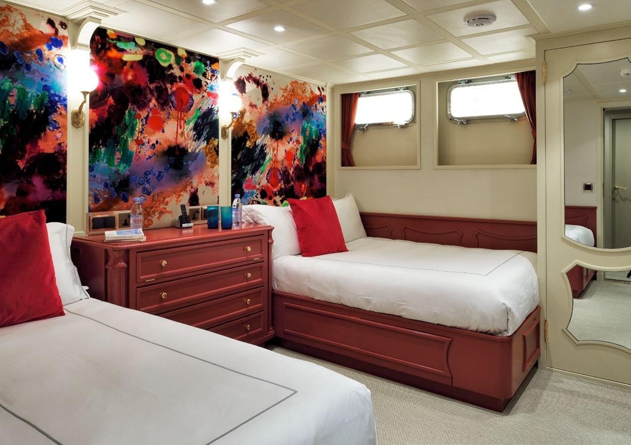 a bedroom with a bed and a painting on the wall aboard SANOO Yacht for Sale