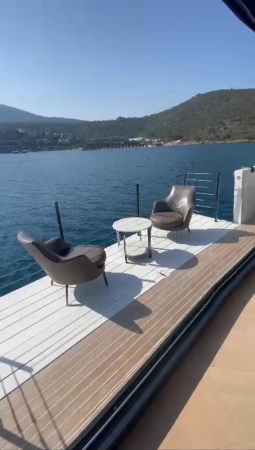 a chair on a deck overlooking a body of water aboard ARCADIA 100 Yacht for Sale