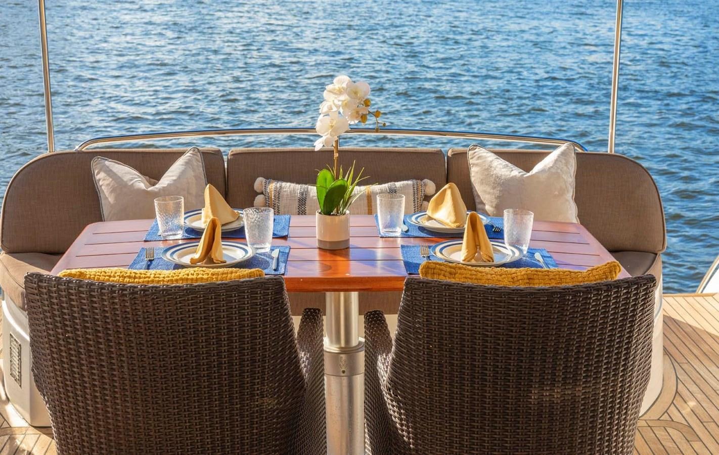a table with chairs and a plant on it aboard UNFORGETTABLE Yacht for Sale