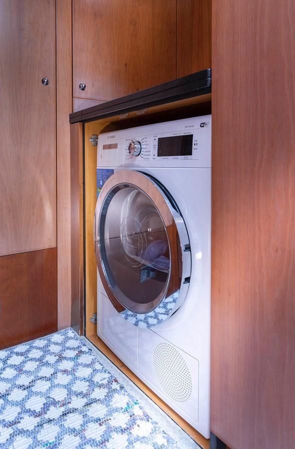 a washing machine in a wooden room aboard UNFORGETTABLE Yacht for Sale