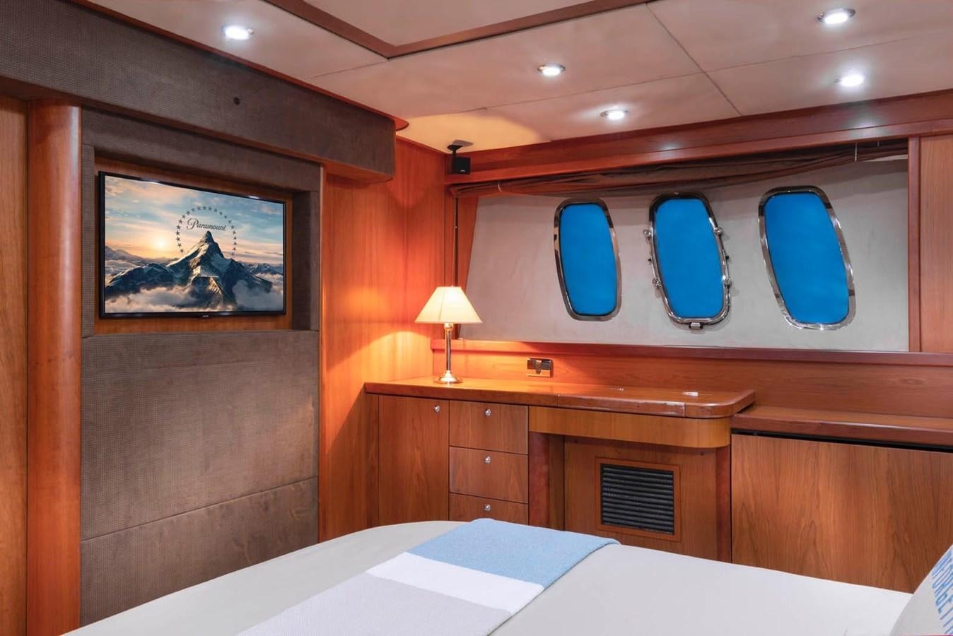 a room with a bed and a painting on the wall aboard UNFORGETTABLE Yacht for Sale