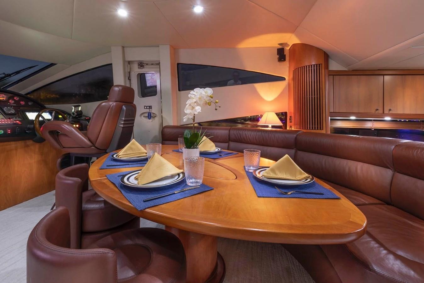 a dining table with a vase of flowers on it aboard UNFORGETTABLE Yacht for Sale
