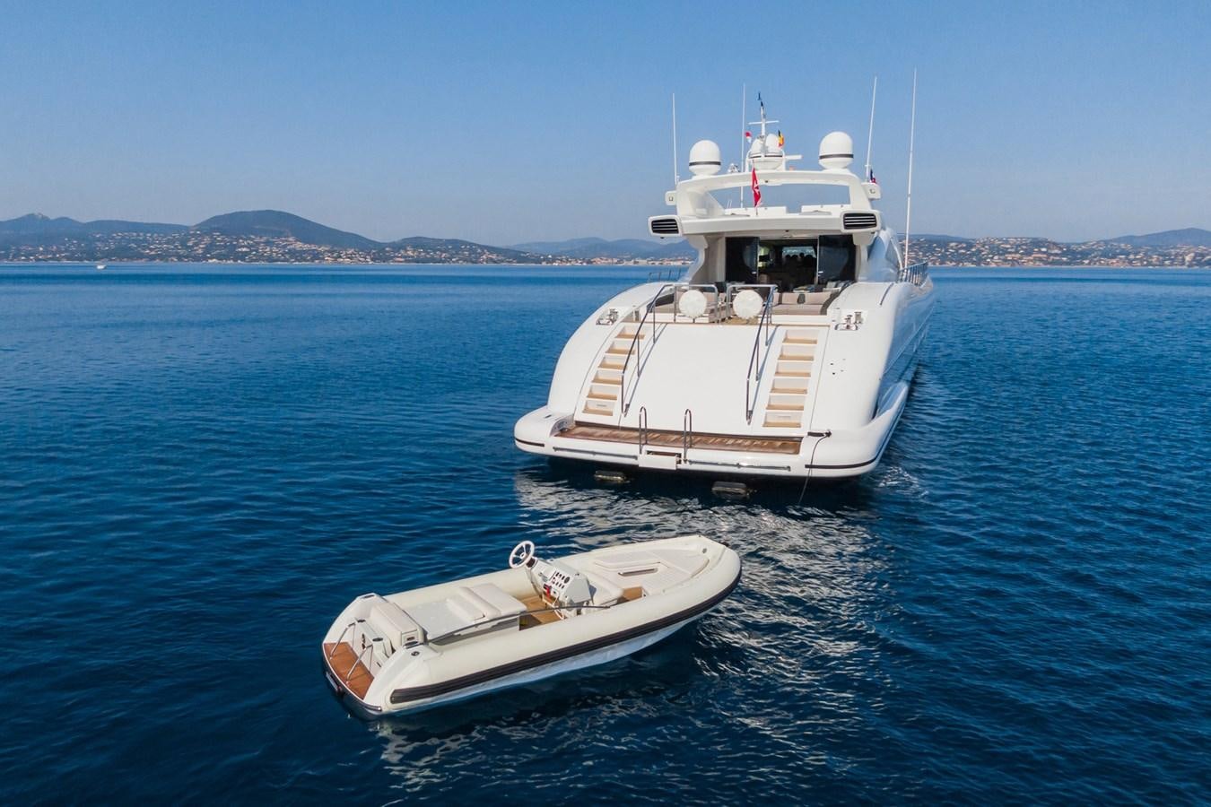 a boat and a motor boat in the water aboard MANGUSTA 130 Yacht for Sale