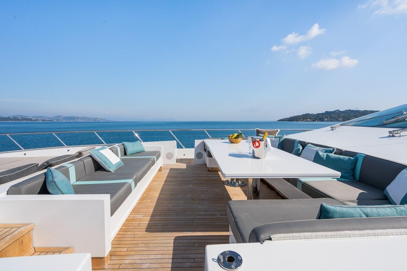 a deck with a row of boats on it and a body of water in the background aboard MANGUSTA 130 Yacht for Sale