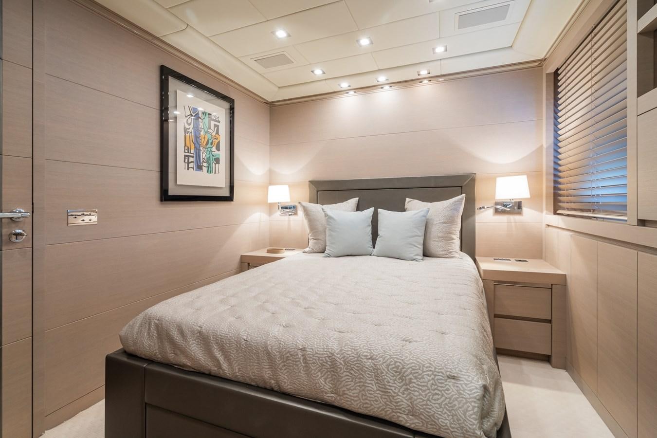 a bed with a white bed spread aboard MANGUSTA 130 Yacht for Sale