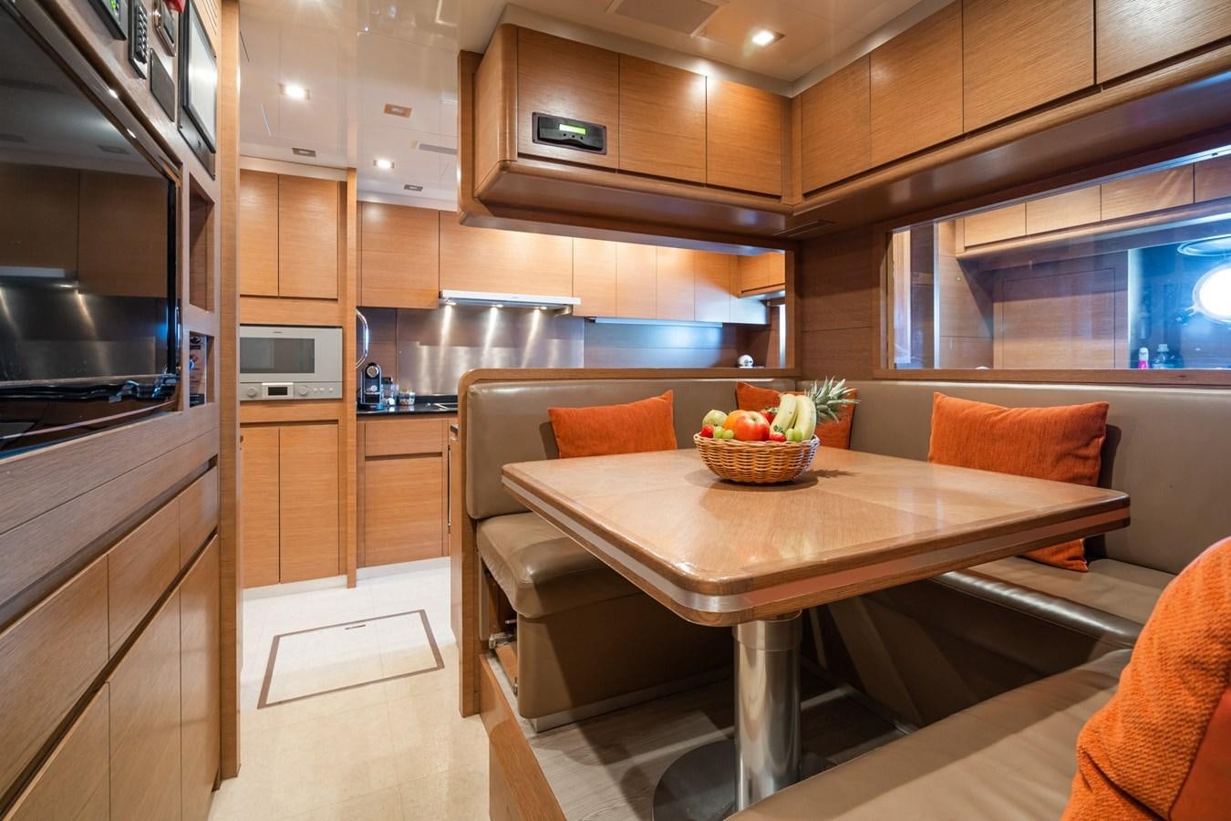 a kitchen with a table and chairs aboard MANGUSTA 130 Yacht for Sale