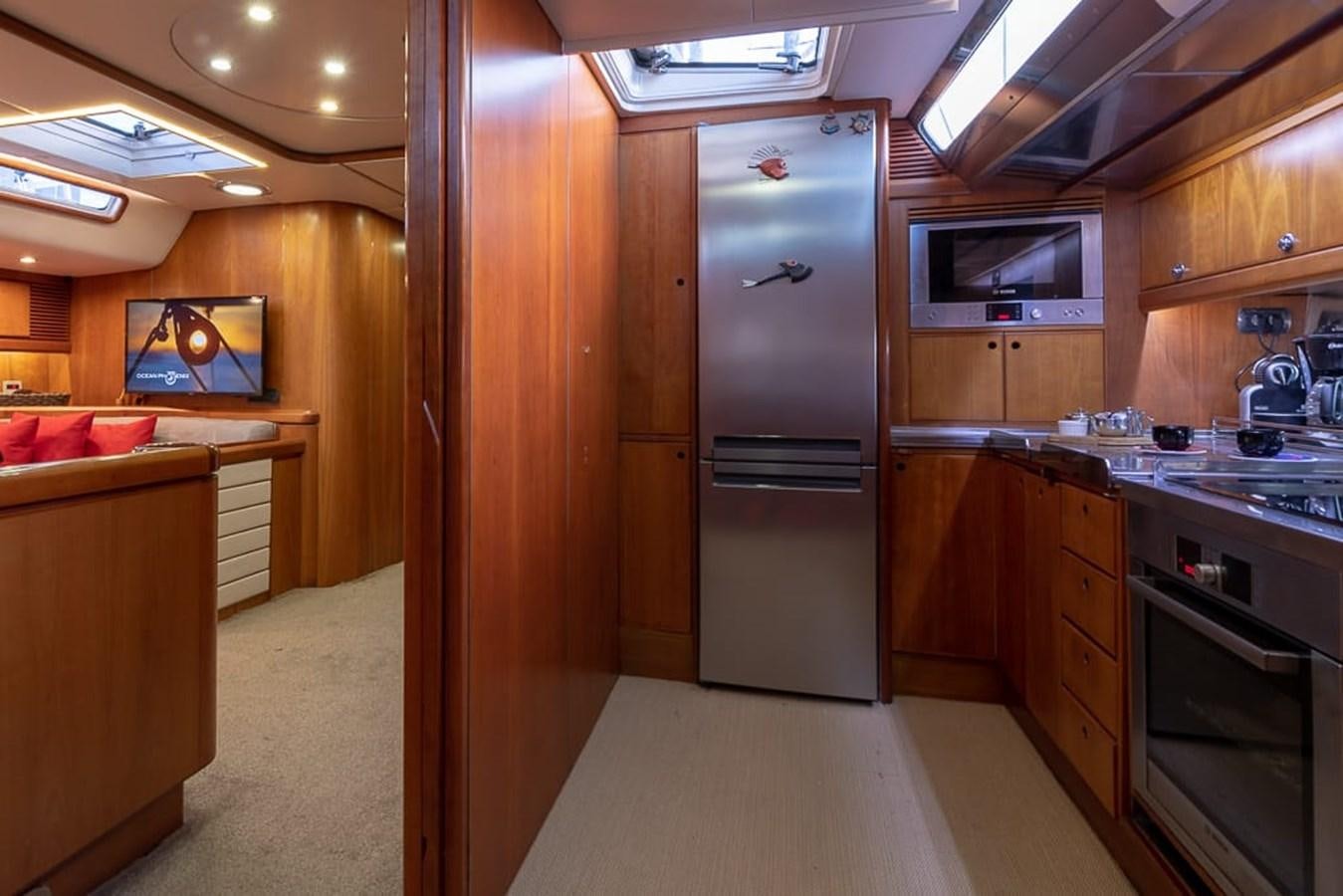 a kitchen with wooden cabinets aboard OCEAN PHOENIX Yacht for Sale