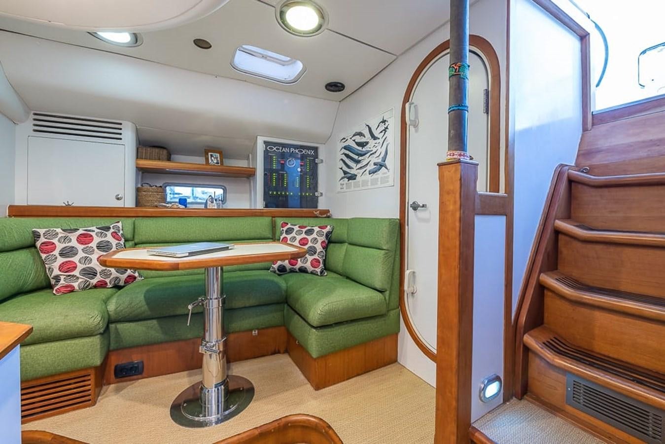 a living room with a table and couches aboard OCEAN PHOENIX Yacht for Sale