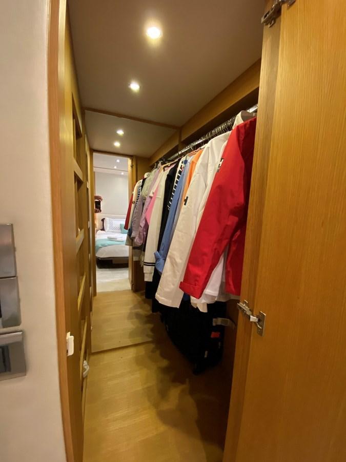 a closet with clothes on the wall aboard MR CORN Yacht for Sale