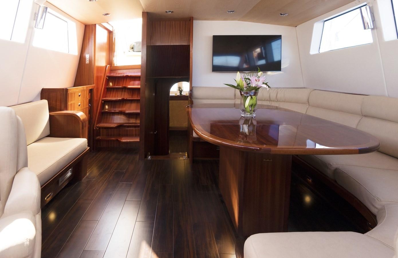 a living room with a wood table aboard LADY FLORE Yacht for Sale