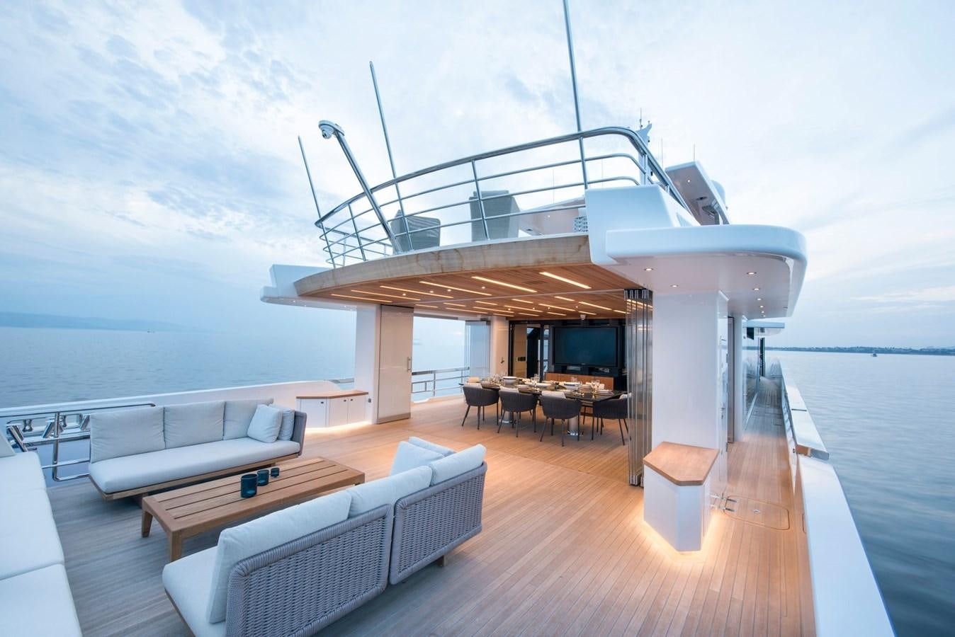 a room with a couch and a table and a tv on the wall aboard PICCOLO @ FLIBS Yacht for Sale