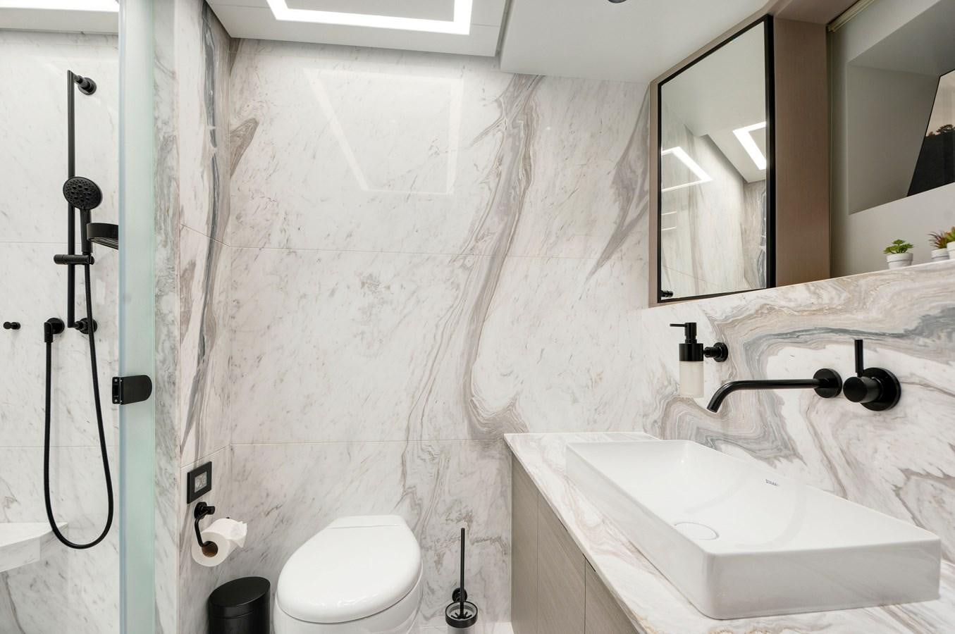 a bathroom with a sink toilet and mirror aboard PICCOLO @ FLIBS Yacht for Sale