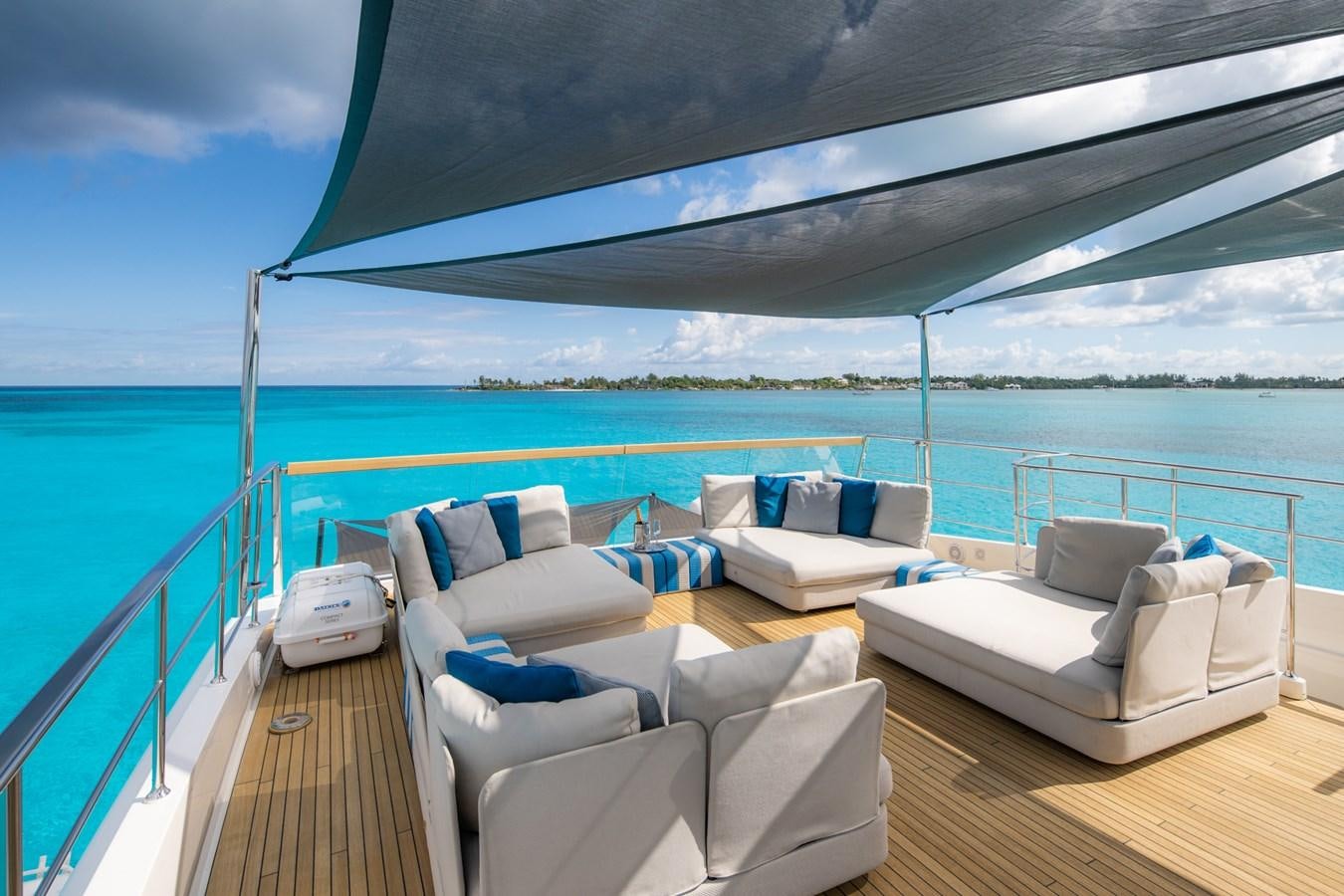 a deck with a large body of water and a large boat in the background aboard HALCYON Yacht for Sale