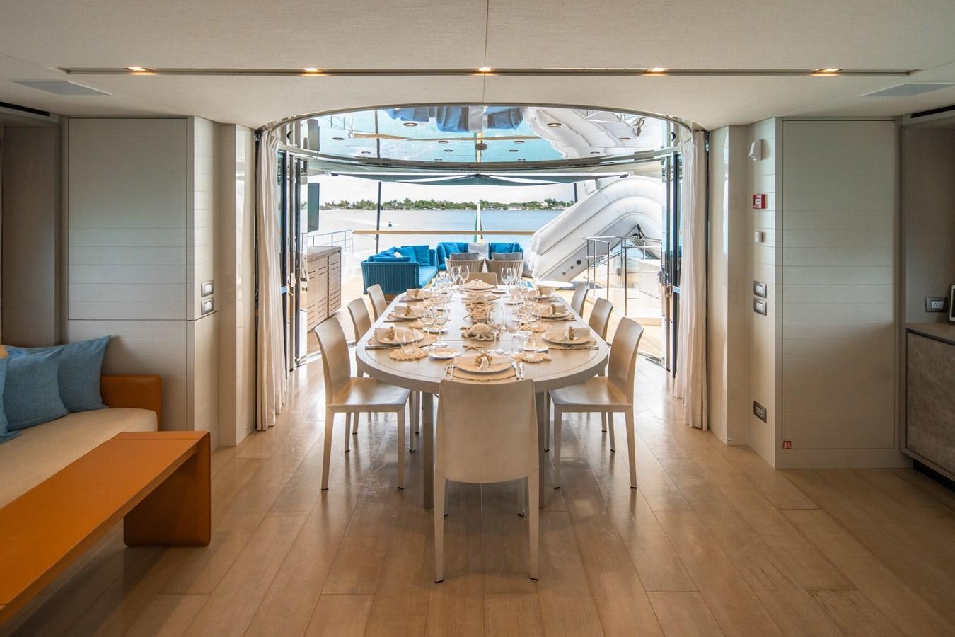 a dining table and chairs in a room with a large window aboard HALCYON Yacht for Sale