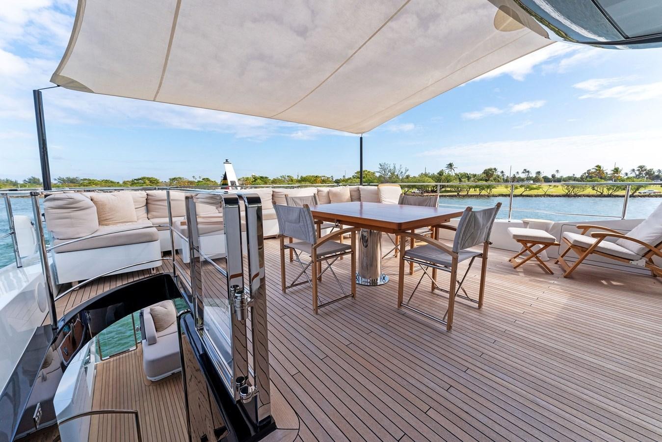 a deck with a table and chairs on it aboard LADY K Yacht for Sale