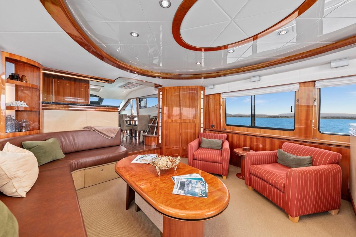 a living room with a table and couches aboard VAMOS A VER Yacht for Sale