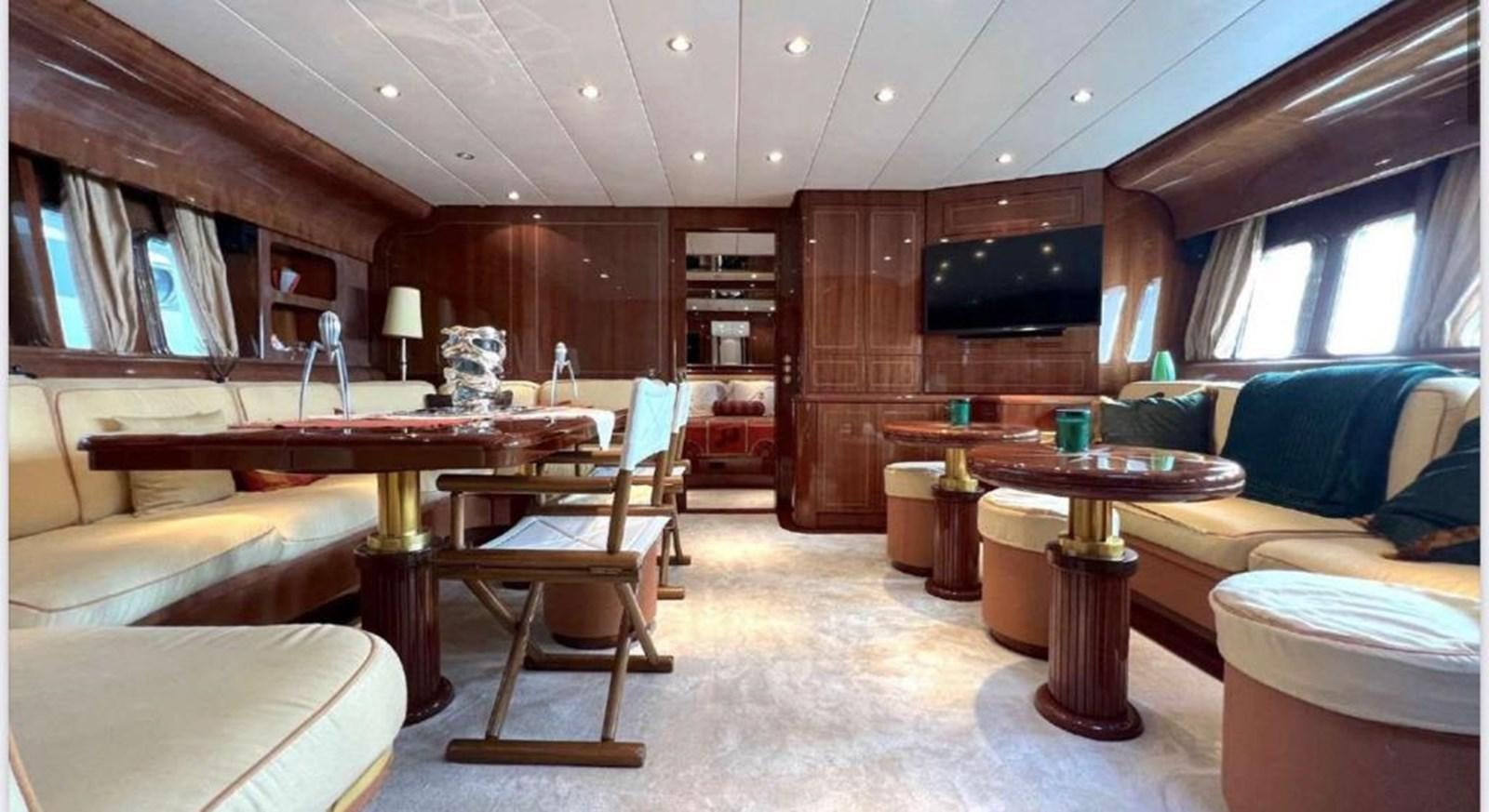 a room with a couch and a table and a tv aboard DG Yacht for Sale