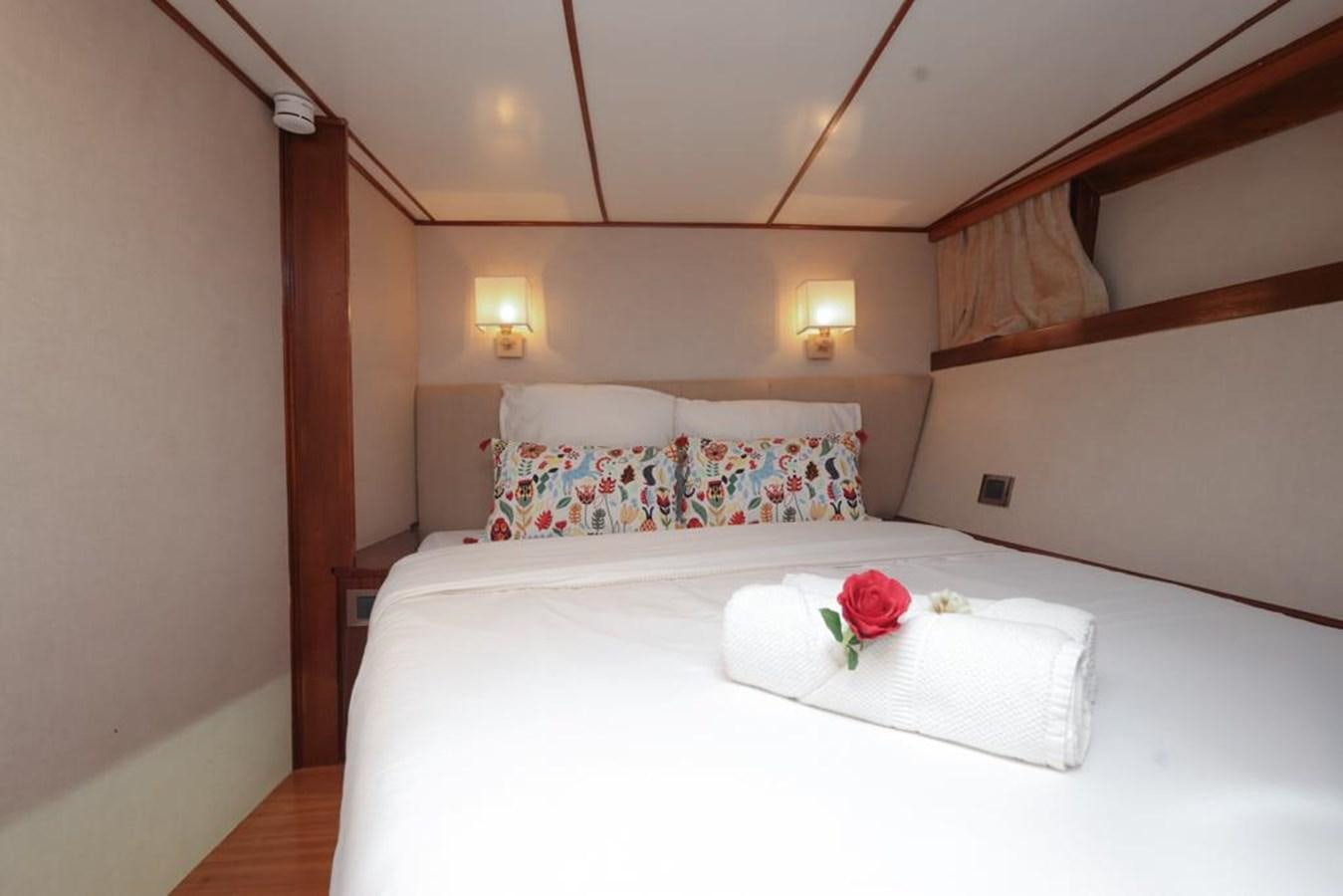 a bed with a rose on the side aboard SISSI Yacht for Sale