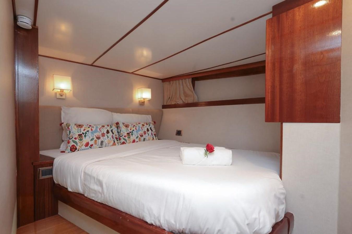 a room with a bed and a lamp aboard SISSI Yacht for Sale
