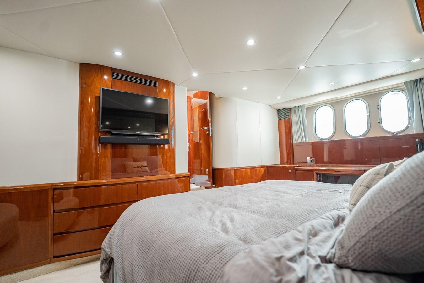 a bedroom with a bed and a television aboard HALF MINE Yacht for Sale