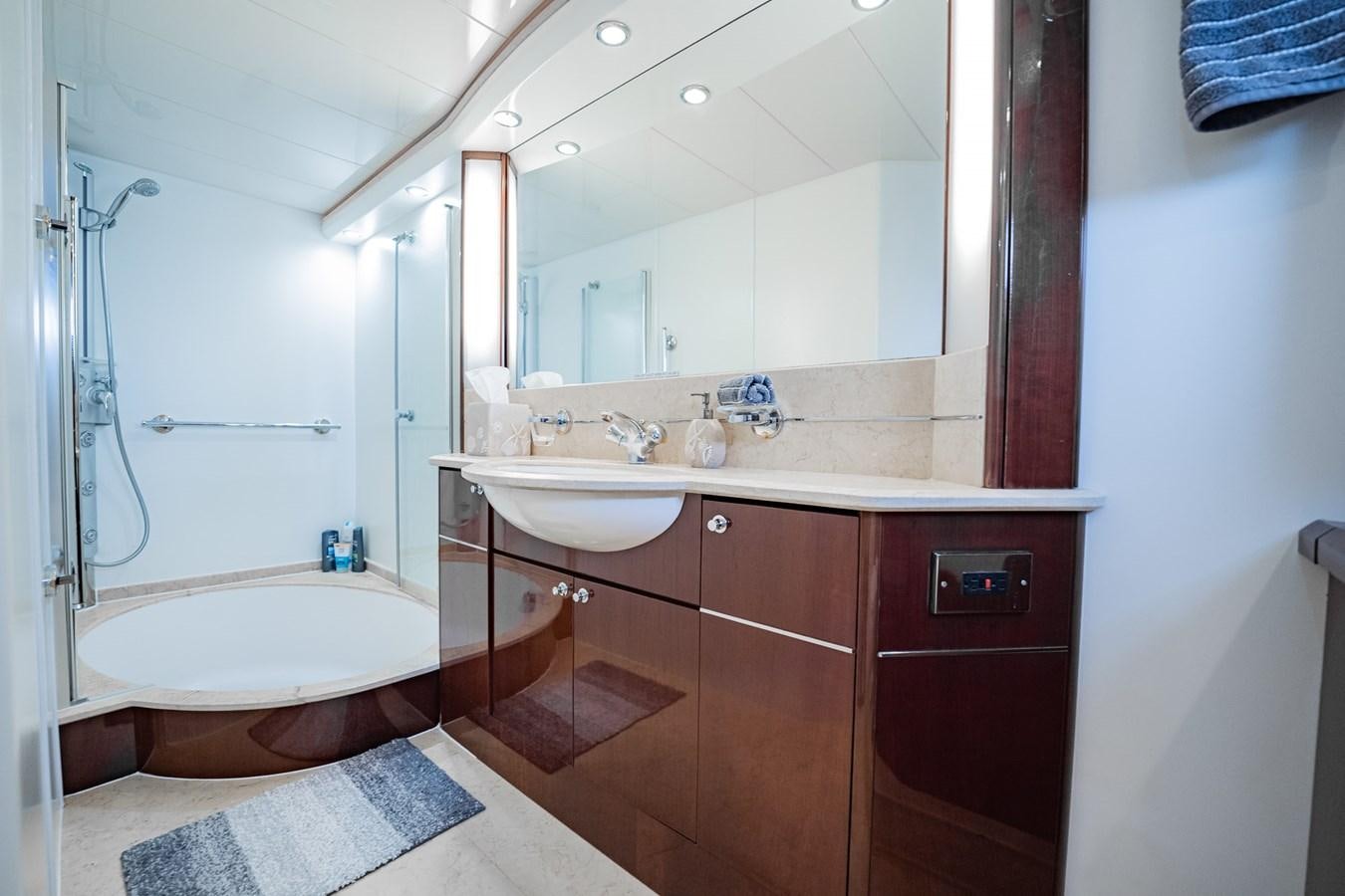 a bathroom with a tub sink and mirror aboard HALF MINE Yacht for Sale