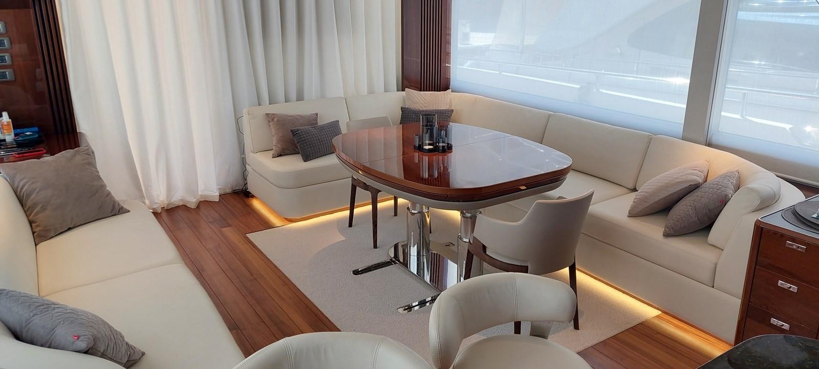 a living room with a table and couches aboard PERLA Yacht for Sale