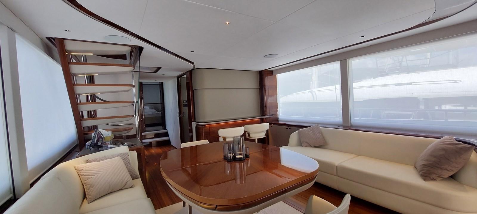 a living room with a table and couches aboard PERLA Yacht for Sale