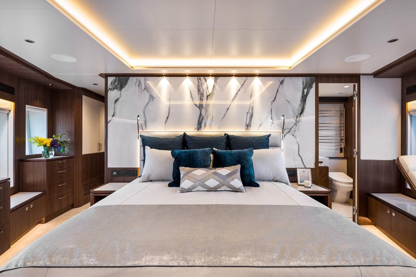 a bed with a blue pillow aboard HORIZON FD110 Yacht for Sale