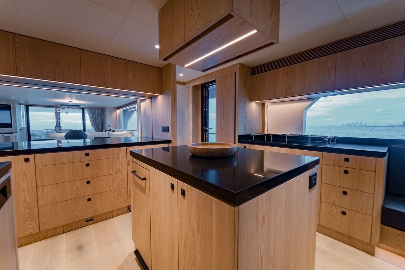 a kitchen with wooden cabinets aboard HORIZON FD110 Yacht for Sale
