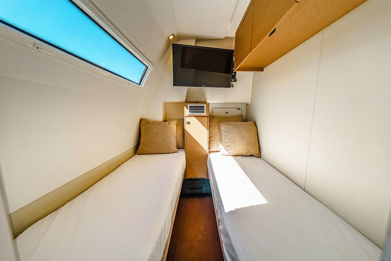 a room with a bed and a tv on the wall aboard 2018 PRESTIGE 680 Yacht for Sale