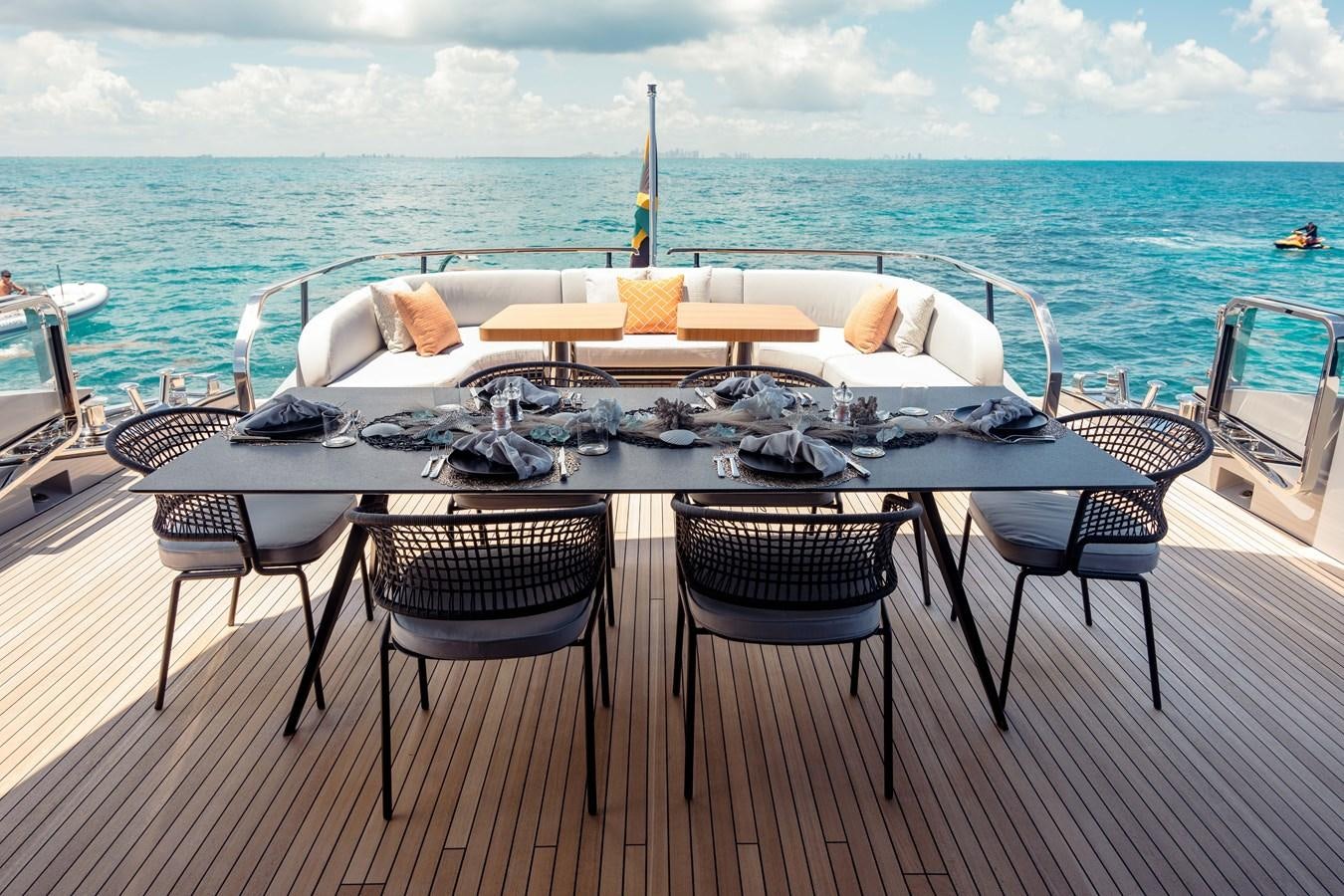 a table with chairs on it next to a body of water aboard OFFLINE Yacht for Sale