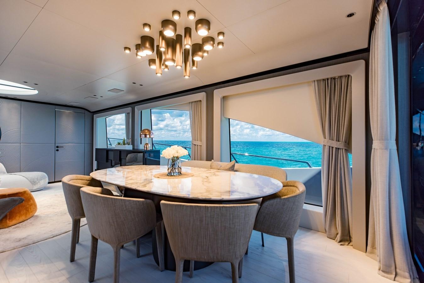 a dining table with chairs and a large window aboard OFFLINE Yacht for Sale