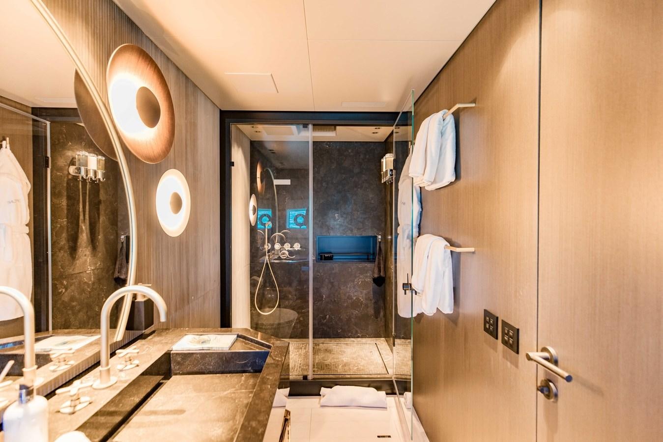 a bathroom with a shower and sinks aboard OFFLINE Yacht for Sale