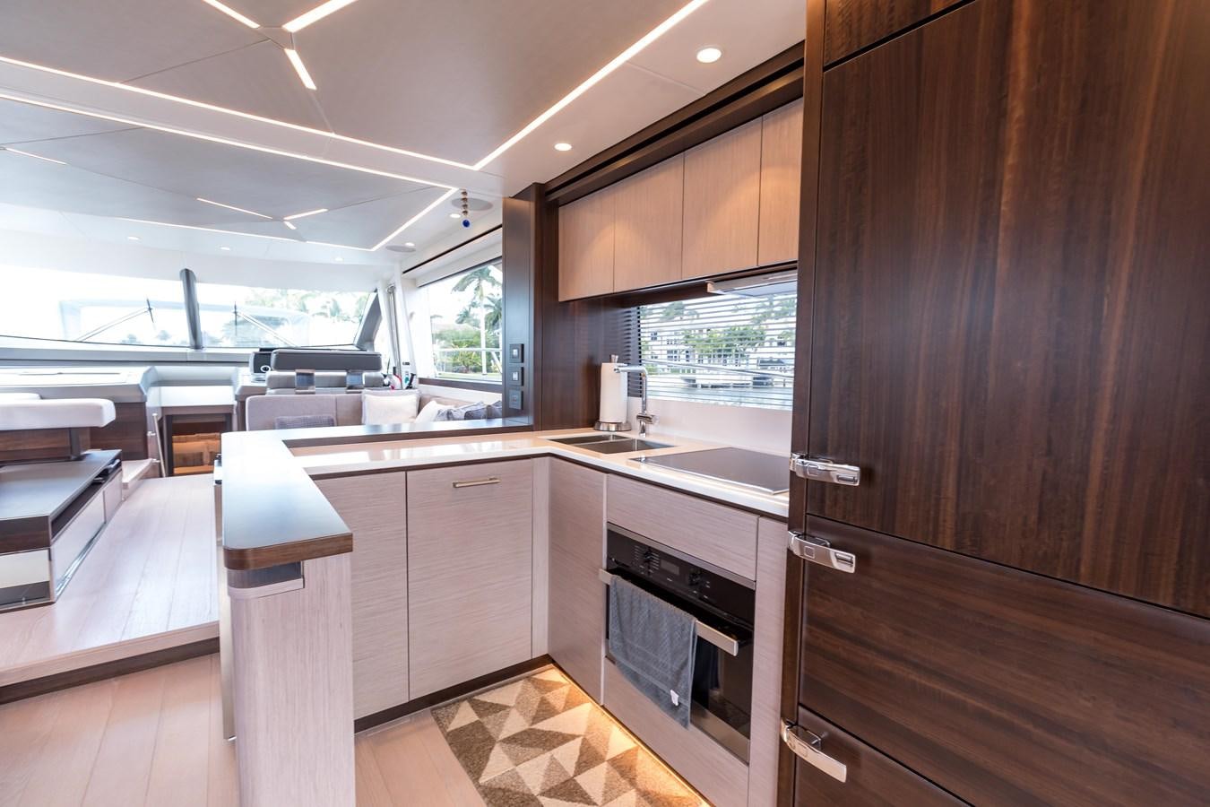 a kitchen with wooden cabinets aboard NAVAL Yacht for Sale