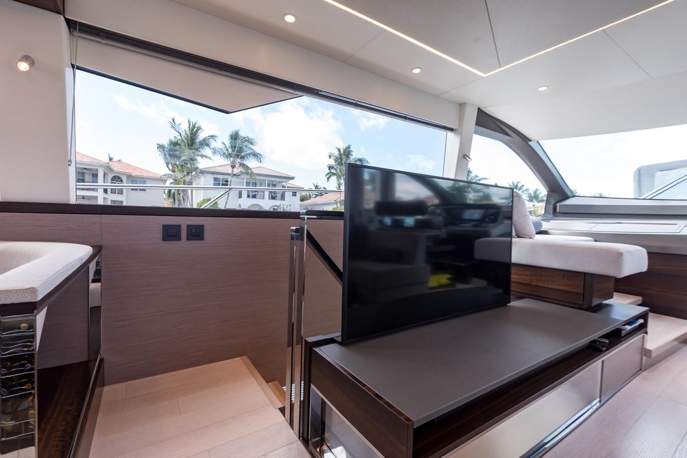 a room with a large window and a table with chairs and a television aboard NAVAL Yacht for Sale