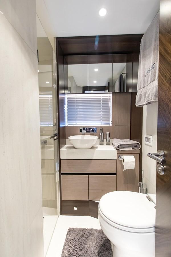 a bathroom with a sink toilet and a mirror aboard NAVAL Yacht for Sale