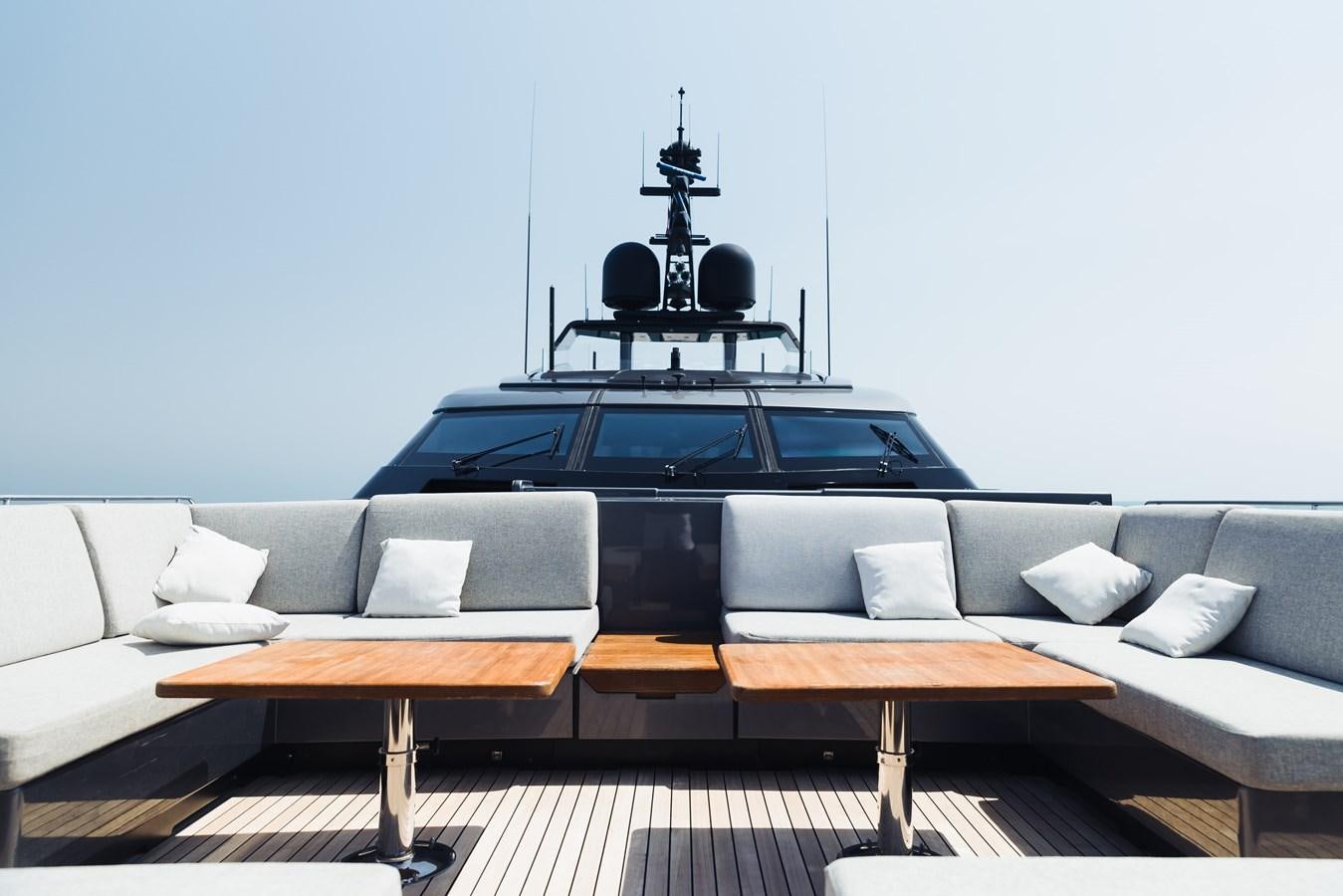 a black and white piano on a wooden table in a room with a couch and a white wall aboard LUCKY ME Yacht for Sale