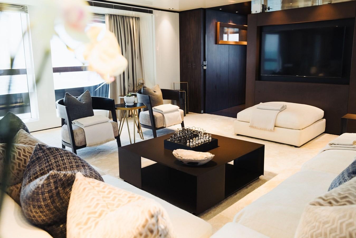 a living room with a tv and furniture aboard LUCKY ME Yacht for Sale